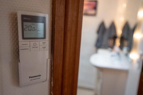 a clock on a wall next to a bathroom at Skylight Lodge in Horsens