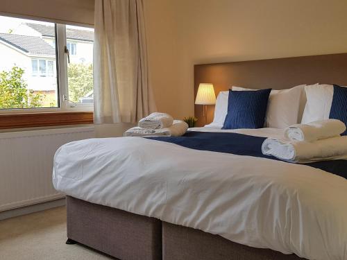 a bedroom with a large bed with towels on it at Argyle View in Dunblane