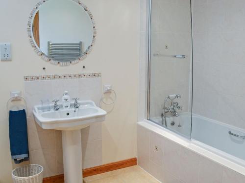 a bathroom with a sink and a shower and a mirror at Fairfield in Ackergill