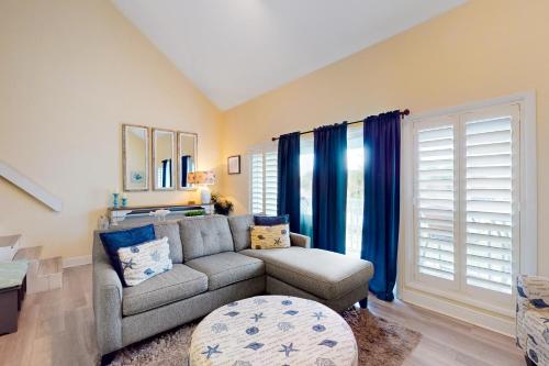 a living room with a couch and blue curtains at Sand Dollar W202 in Pensacola Beach