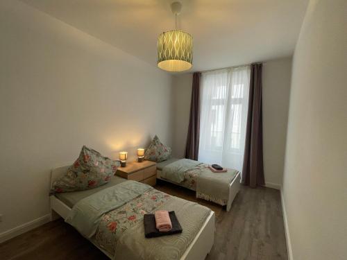 a bedroom with two beds and a chandelier at Ferienwohnung * Pension Luisengrün * Magenta TV Netflix 1Gb/s Internet WLAN/Wifi Waschmaschine in Chemnitz