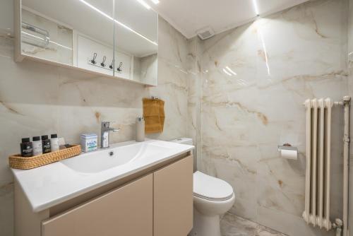 een badkamer met een witte wastafel en een toilet bij Υπέροχο διαμέρισμα στο Ίλιον σύνορα με Πετρούπολη in Athene