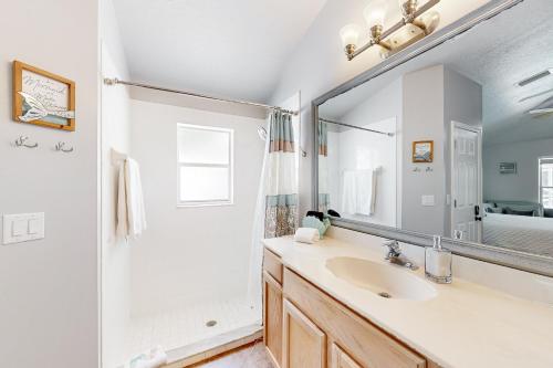 a bathroom with a sink and a shower and a mirror at Eastwood Hideaway in Fort Pierce