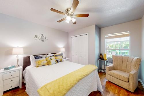 a bedroom with a bed and a ceiling fan and a chair at Eastwood Hideaway in Fort Pierce