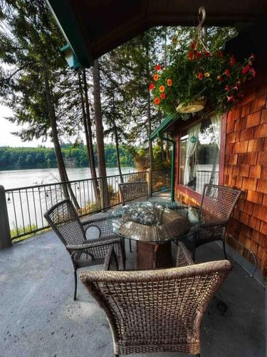 a patio with chairs and a table with flowers on it at Hammersley Inlet- Oyster beach, Relaxing Views in Shelton