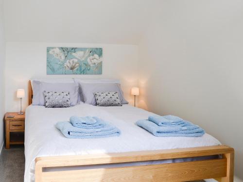 a bedroom with a bed with blue towels on it at Little Cottage in Wigtown