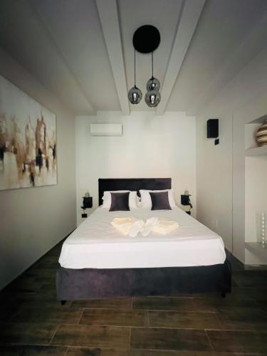 a bedroom with a large white bed in a room at VICOLO SAN GAETANO -luxury rooms- in Catania