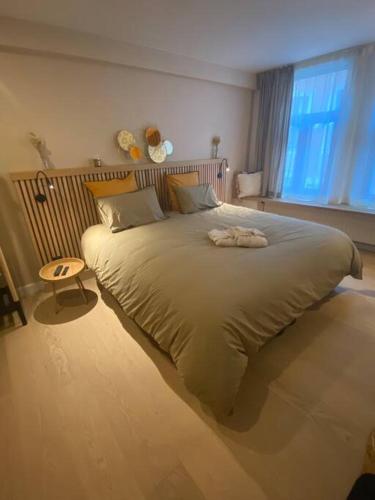 ein großes Bett in einem Schlafzimmer mit Fenster in der Unterkunft Maison de ville - 4 personnes - Ô coeur de Spa in Spa