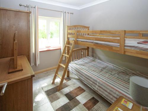 a bedroom with two bunk beds and a desk at Squirrels Drey in North Walsham