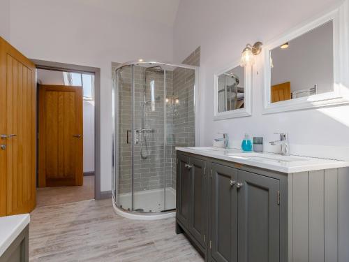 a bathroom with a shower and a sink and a mirror at The Hayloft - Uk34565 in Whitchurch