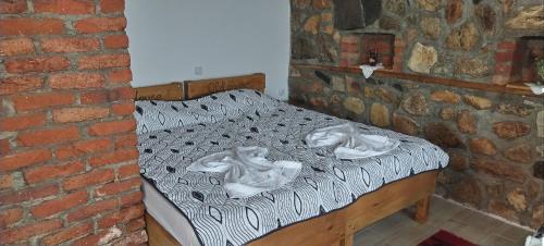 a bedroom with a bed in a brick wall at Villa Old House BN in Bitola
