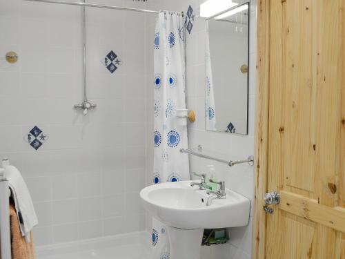 a white bathroom with a sink and a shower at Laurel Bank in Alyth