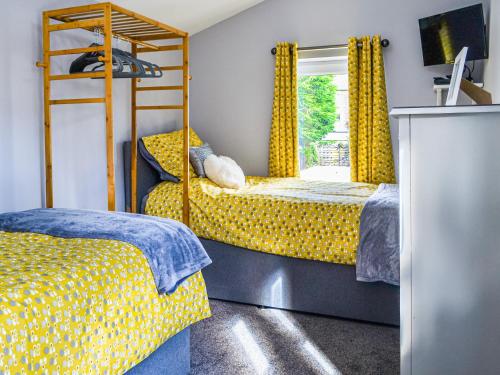 een slaapkamer met 2 bedden en een stapelbed bij Loweys Harbour Cottage in Bridlington