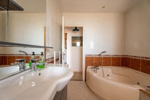 a bathroom with two sinks and a bath tub at Casa con vistas a la Bahia de Roses in Selva de Mar