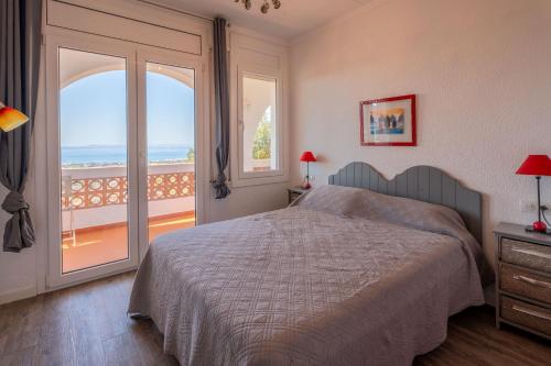 a bedroom with a bed and a view of the ocean at Casa con vistas a la Bahia de Roses in Selva de Mar