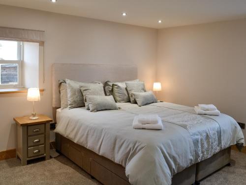ein Schlafzimmer mit einem großen Bett mit zwei Handtüchern darauf in der Unterkunft Greengill Farm Holiday Cottage - Ukc2768 in Gilcrux