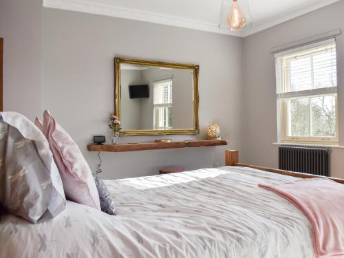 een slaapkamer met een bed met een spiegel aan de muur bij Dark Lane in Chesterfield