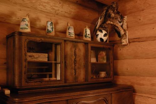 a wooden cabinet with cups and vases on top of it at Viesu nams “Kalna Raskumi” in Vecpiebalga