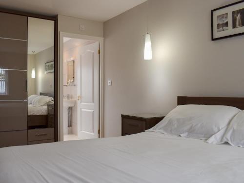een slaapkamer met een wit bed en een badkamer bij Hollies Cottage 11 - Ukc4534 in Martock