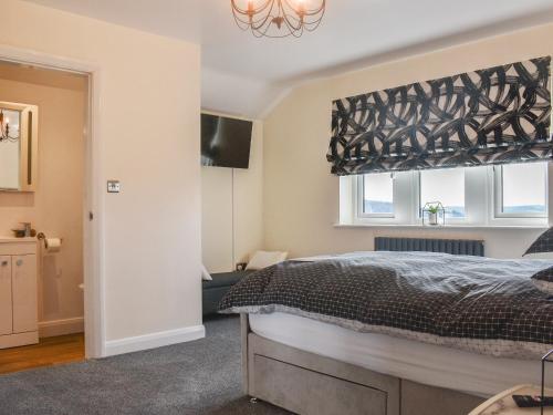 a bedroom with a bed and a window at Kinneret Apartment in Silsden