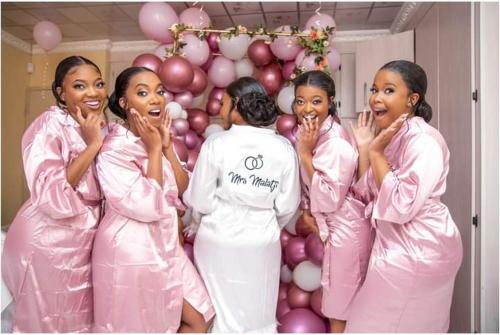 a group of women in pink suits standing in front of a balloon at The Holiday House in Hartbeespoort