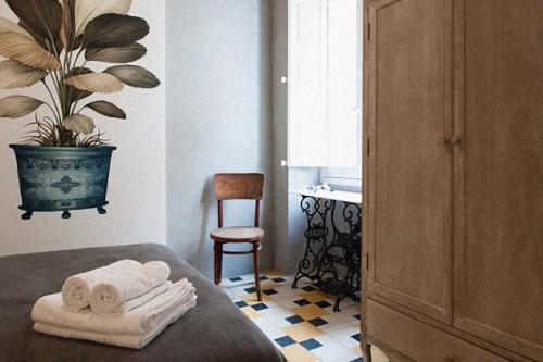 a bedroom with a bed with towels and a plant at Dar Isla, in the heart of the Three Cities, Malta in Senglea