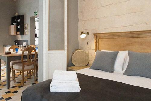 a bedroom with a bed and a table and a dining room at Dar Isla, in the heart of the Three Cities, Malta in Senglea