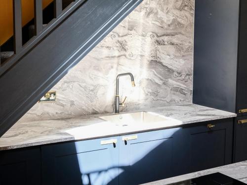 a bathroom with a sink and a marble wall at The Gold Apartment - UK40025 in Southport