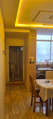 a kitchen with a table and a bathroom with a toilet at Aziz nahda jd in Agadir