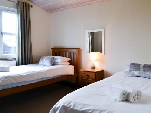 WilberfossにあるAppletree Lodgeのベッドルーム1室(ベッド2台、窓、ランプ付)