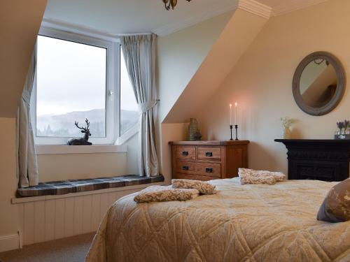 ein Schlafzimmer mit einem großen Bett und einem Fenster in der Unterkunft Ben Ledi View in Callander