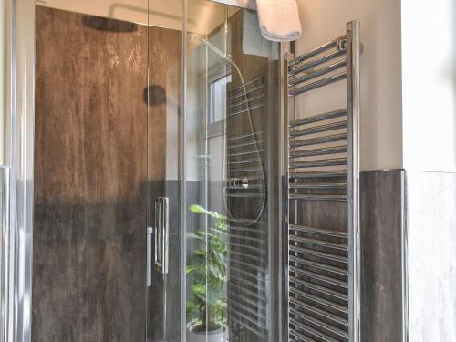 a shower with a glass door with a plant at The Workshop in Ferndown