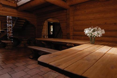 a wooden table with a vase of flowers on it at Viesu nams “Kalna Raskumi” in Vecpiebalga