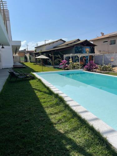 a swimming pool in a yard next to a house at Pousada Mali in Canoa Quebrada