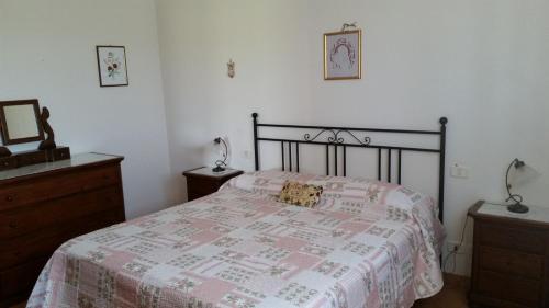 a bedroom with a bed and a dresser and a mirror at Agriturismo Le Giunchiglie in Alberese