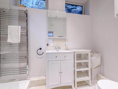 a white bathroom with a sink and a shower at Sunny Shores - Uk32245 in Aberdyfi