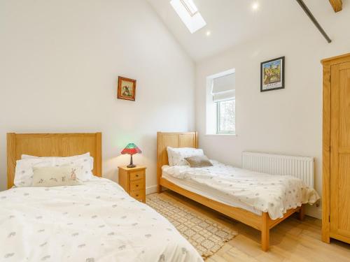 een slaapkamer met 2 bedden en een raam bij Abigails Cottage in Trimdon Grange