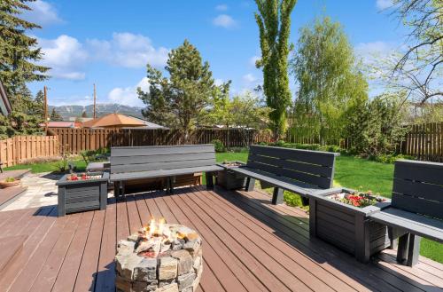 a patio with two benches and a fire pit at Good Medicine Lodge in Whitefish
