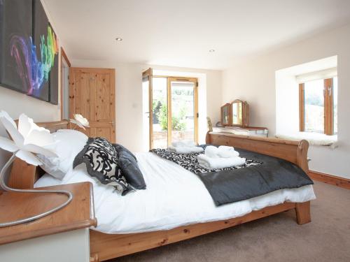 a bedroom with a large bed with black and white pillows at The Cow Shed in Tiverton
