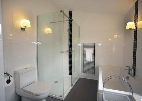 a bathroom with a shower and a toilet and a tub at High Lodge in Darsham