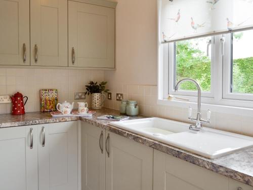 a kitchen with a sink and a window at Cedar Lodge in Herstmonceux