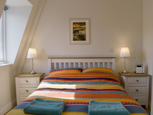 a bedroom with a bed with two night stands and two lamps at Sandcastles in Swanage