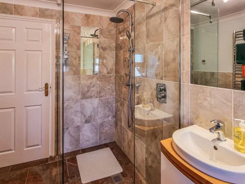a bathroom with a shower and a sink at Whitney Cottage in Broadway