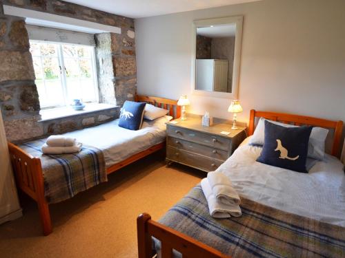 sypialnia z 2 łóżkami i oknem w obiekcie The Long Barn w mieście Crowan