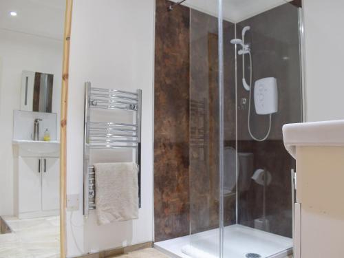 a bathroom with a shower with a glass door at Bramble Cottage in Leven