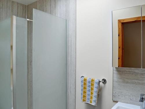 a bathroom with a mirror and a sink at Shoemakers Steading in Hopeman