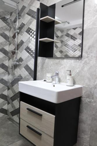 a bathroom with a white sink and a mirror at Apartman ŠafraM in Ðurmanec