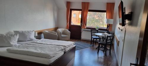 Schlafzimmer mit einem Bett, einem Tisch und Stühlen in der Unterkunft Piets Gästezimmer in Sandstedt