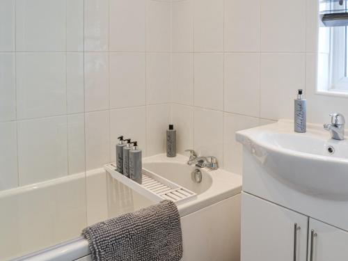a white bathroom with a sink and a bath tub at Goths Lane in Beverley