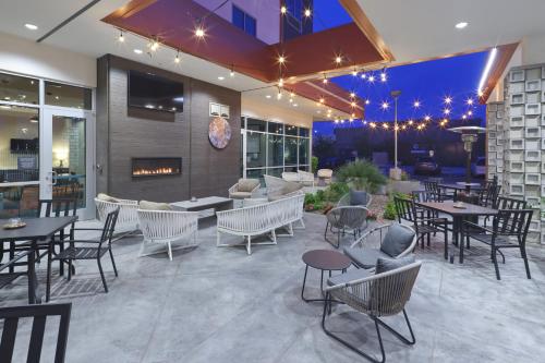 a restaurant with tables and chairs and a fireplace at Hilton Garden Inn Chandler Downtown in Chandler